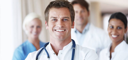 Picture of a group of doctors representing the quality care you will receive at Top Plastic Surgeons in Costa Rica..  The picture shows a doctor in a white shirt with a stethoscope around his neck, and 3 associates standing behind him.