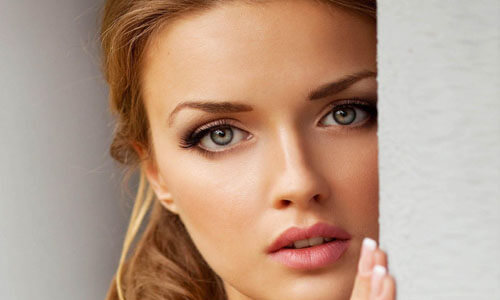 Close-up picture of a beautiful woman, happy with her eyelid lift in San Jose, Costa Rica.  The woman has medium length brown hair and is looking directly at the camera.