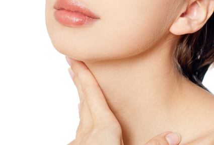 Picture of a woman with short brown hair, turned slightly away from the camera, and happy with her perfect neck lift procedure she had at Top Plastic Surgeons in beautiful San Jose, Costa Rica.  The woman has her hand on her neck showing the results.
